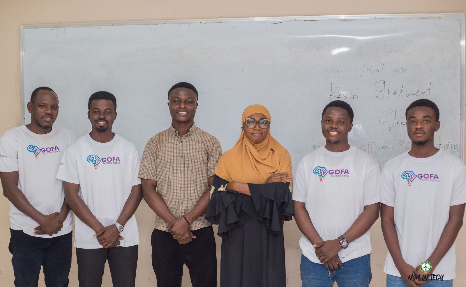 A small group posing with GOFA team members in the classroom.